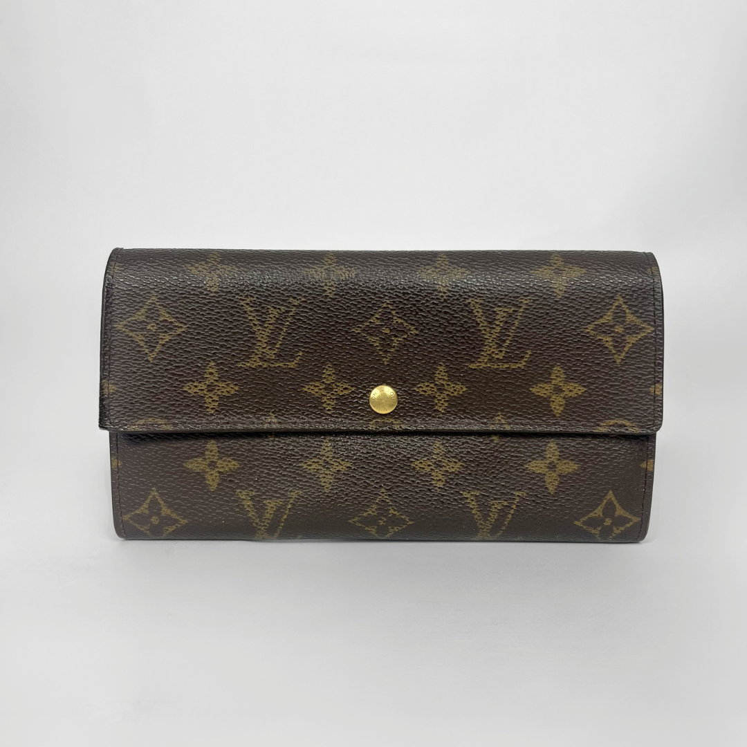 Louis Vuitton wallet with monogram pattern on a white background