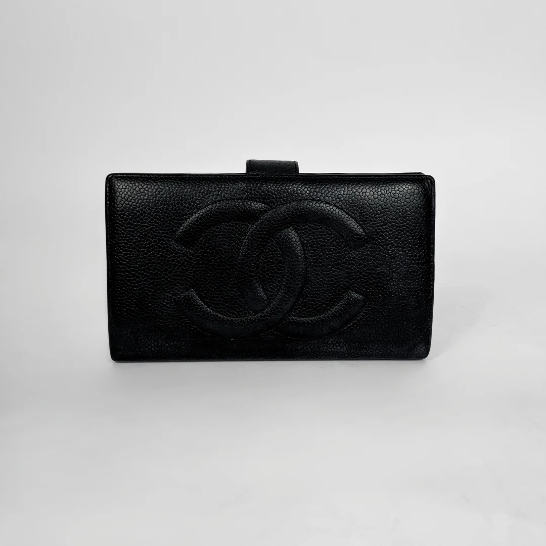 A black textured leather clutch bag with an embossed interlocking CC logo, characteristic of Chanel, set against a plain light gray background.
