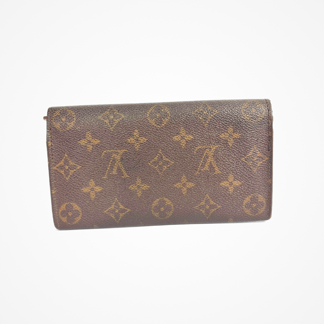 Brown LV wallet with gold monogram pattern on a white background