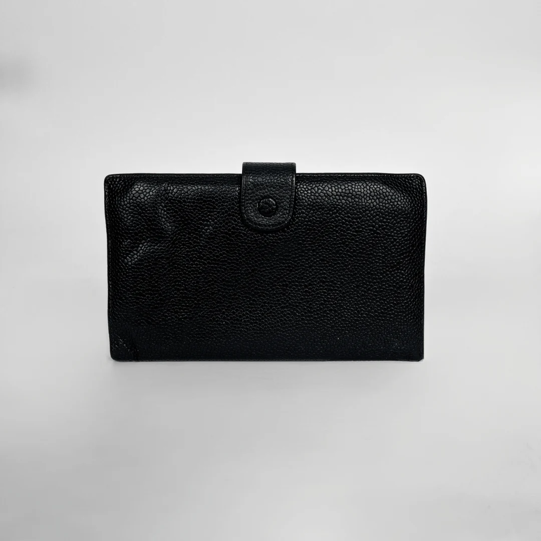 A black textured leather wallet with a snap-button strap closure, photographed against a neutral light gray background.