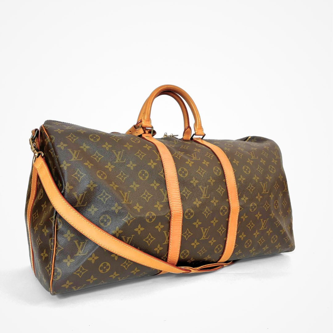 Brown LV duffel bag with monogram canvas and tan leather straps on a white background