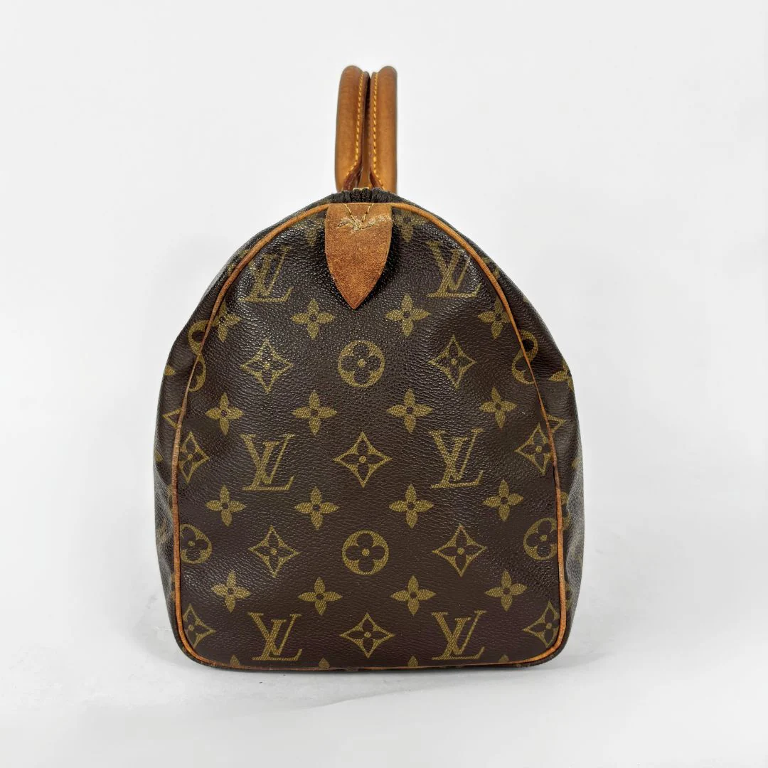 Brown handbag with monogram pattern on a white background