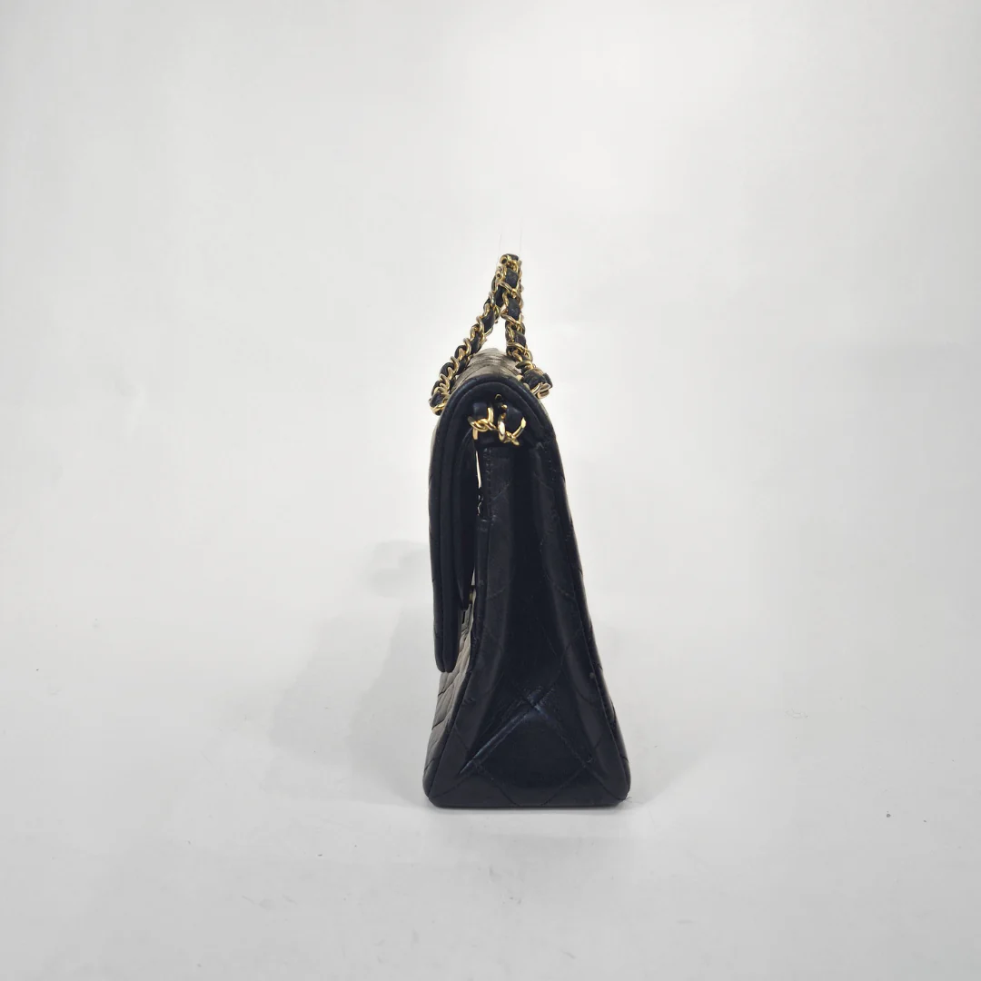 Black handbag with gold chain strap on a white background