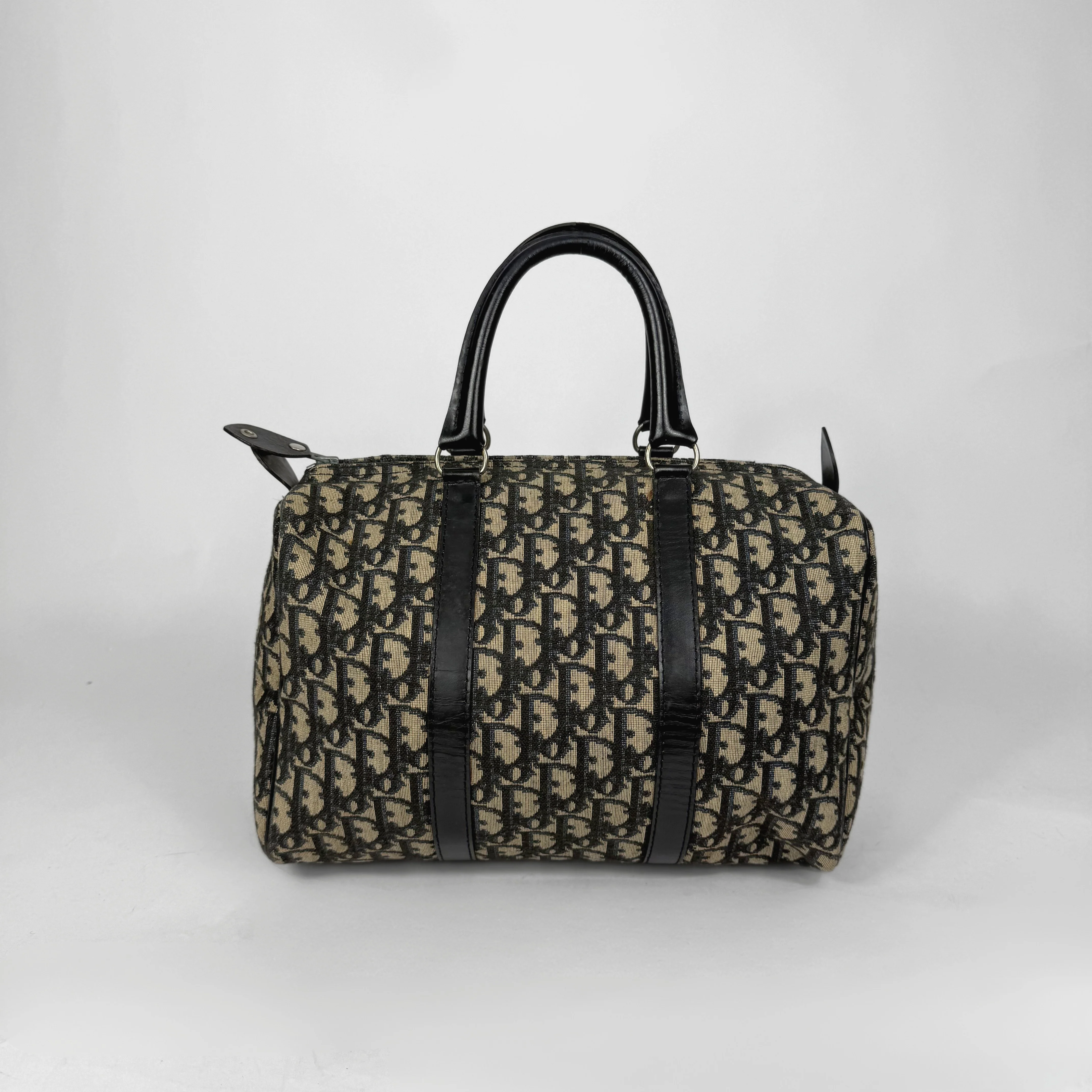 Designer handbag with black handles and straps on a white background