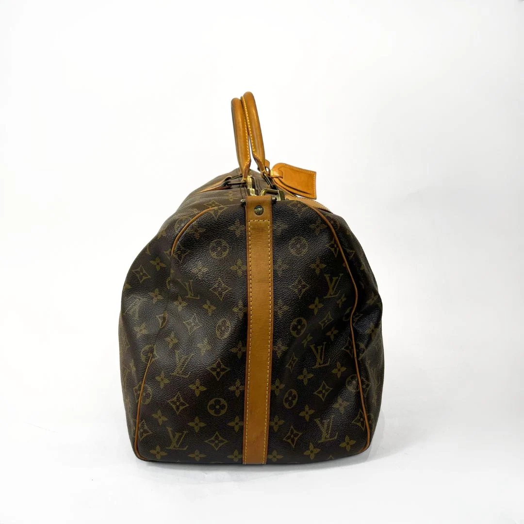 Louis Vuitton monogram handbag with brown leather accents on a white background