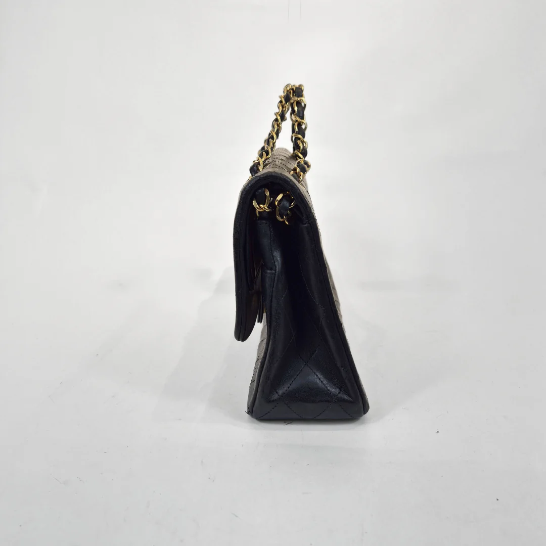 Black handbag with gold chain on a white background