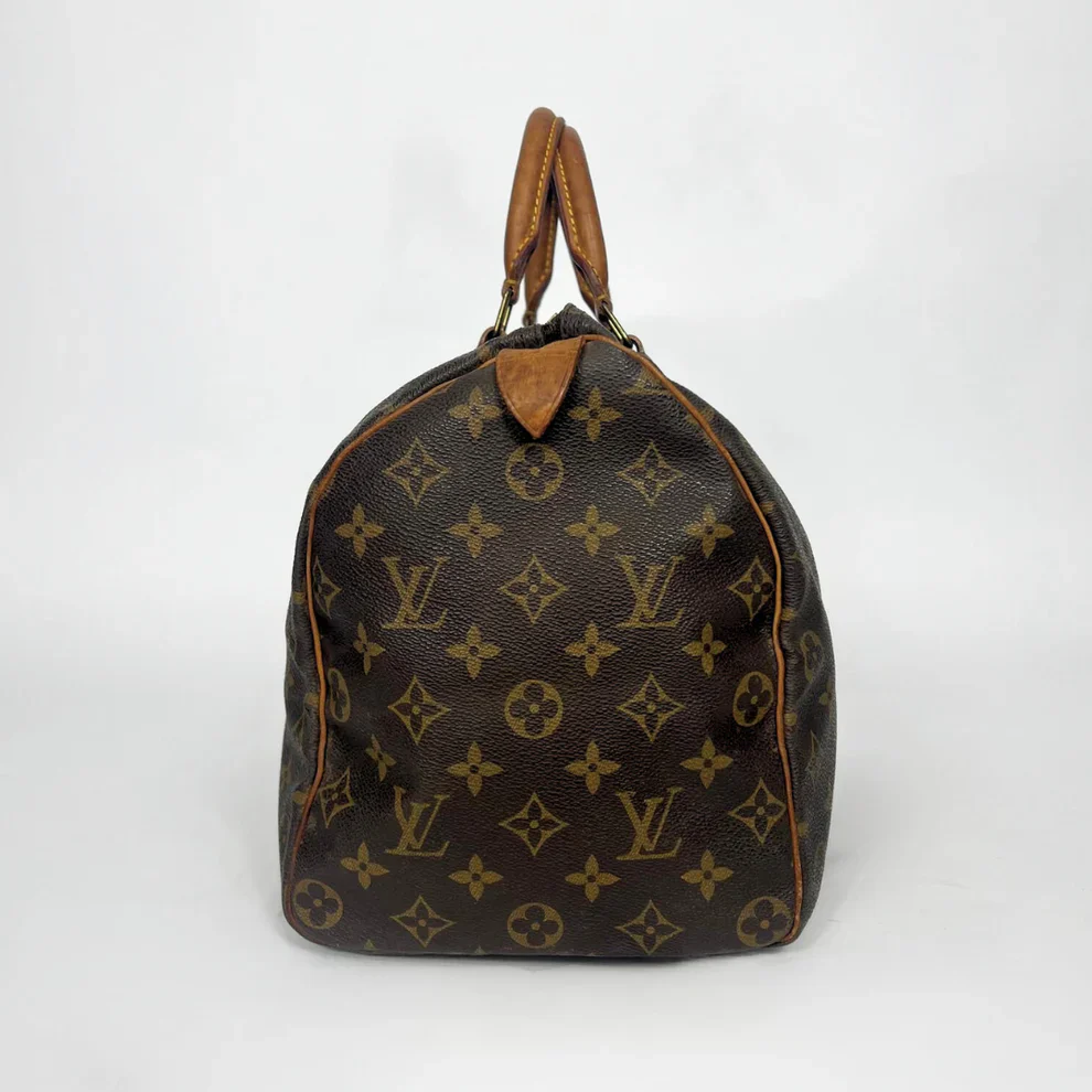 Brown leather handbag with monogram pattern on a white background