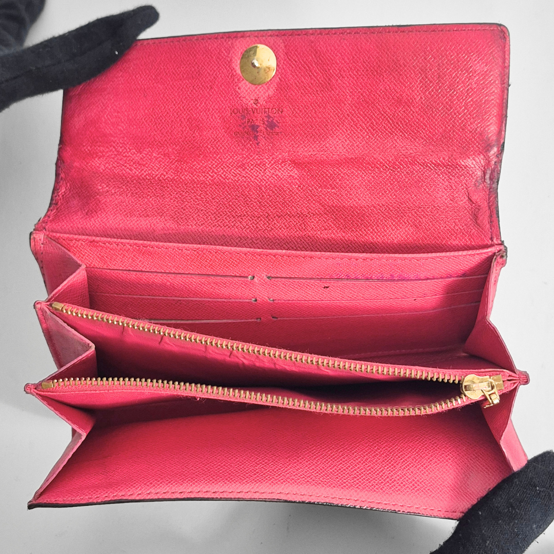 Open red wallet with gold accents on a gray background