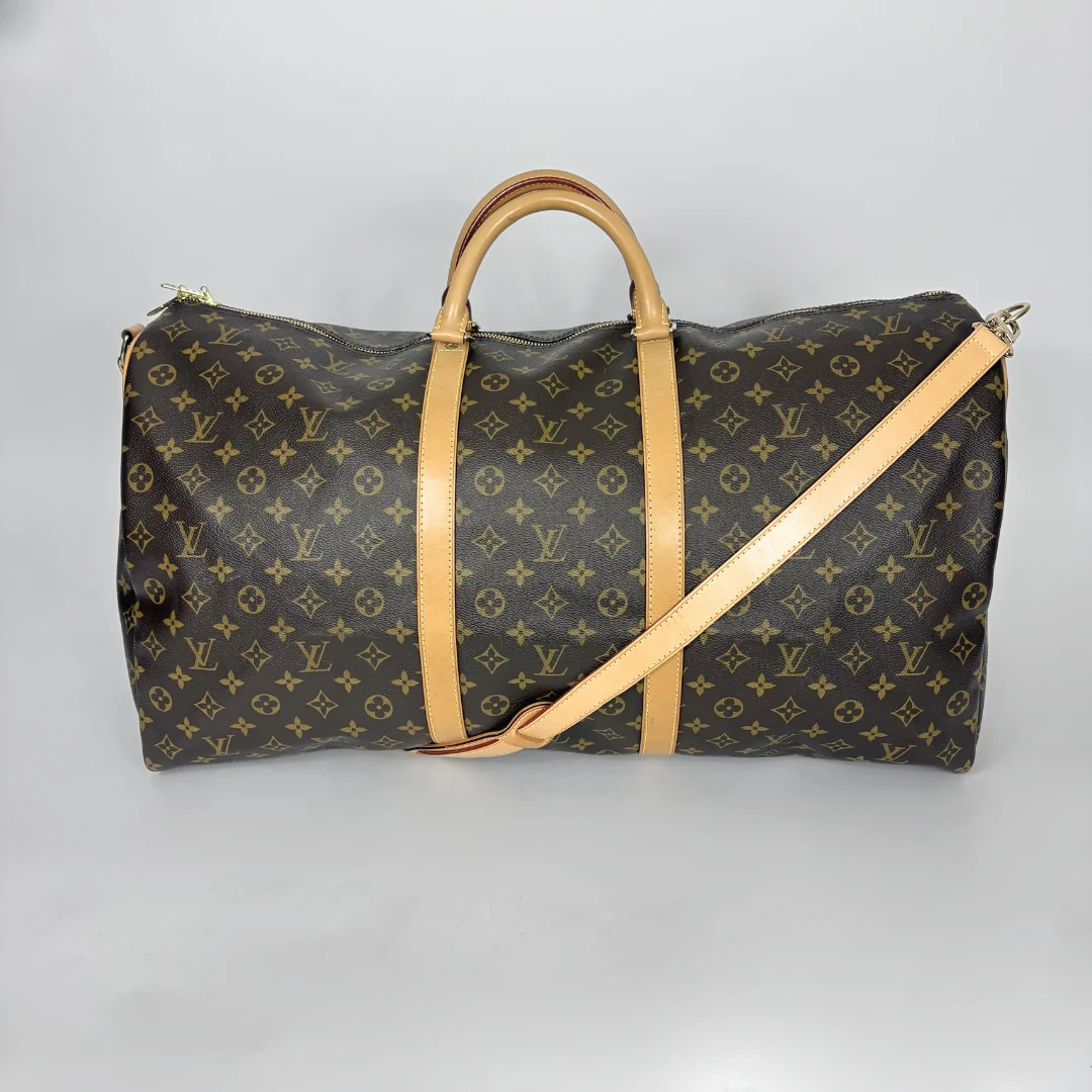 Designer travel bag with monogram pattern on a gray background