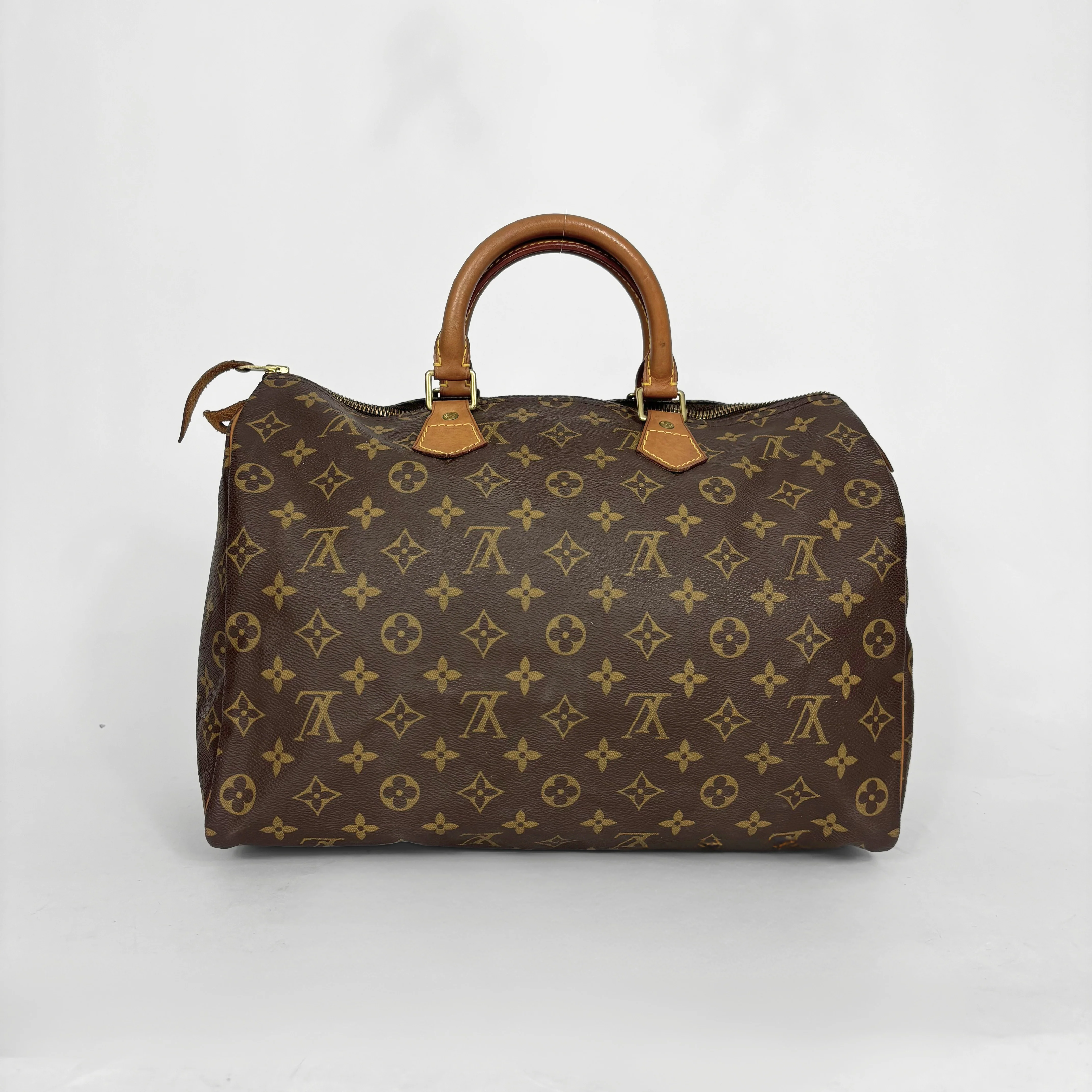 Brown handbag with a monogram pattern on a white background