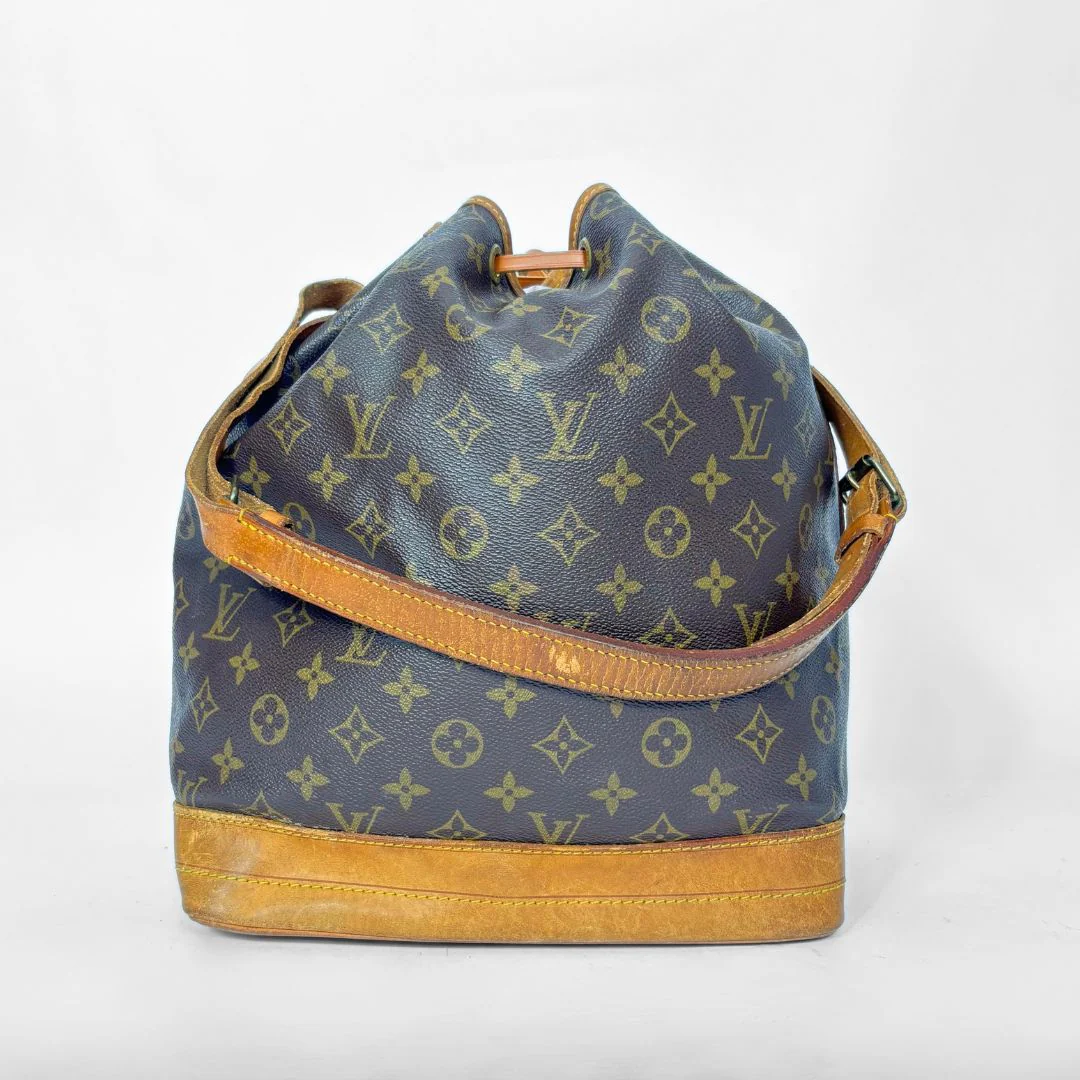 Monogram handbag with brown leather accents on a white background
