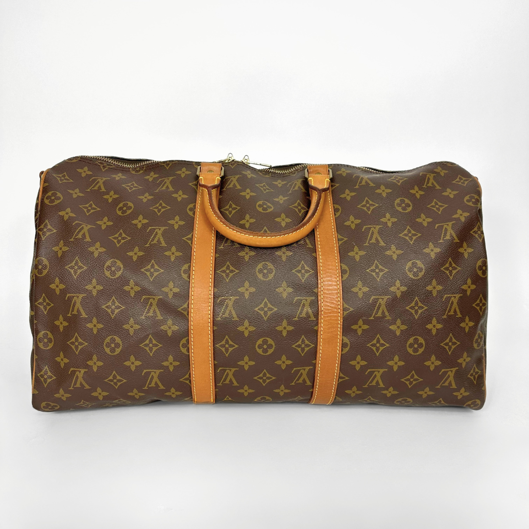 Brown travel bag with tan handles and trim on a white background