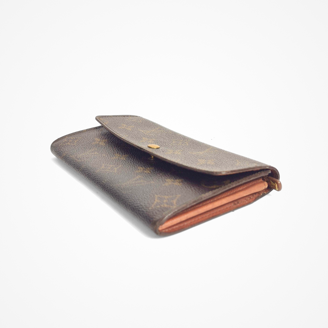 Brown LV wallet with gold monogram pattern on a white background