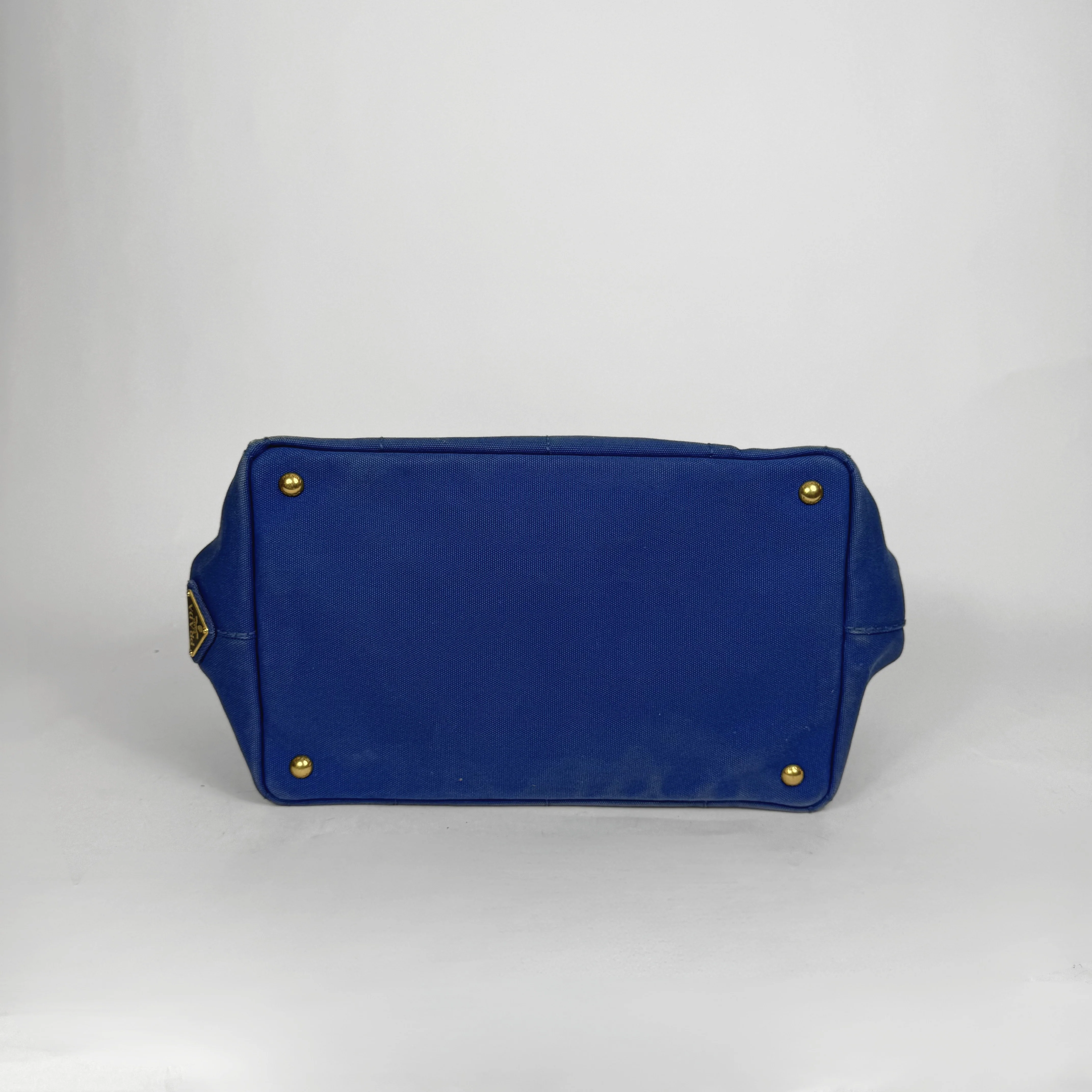 Blue toiletry bag with gold accents on a white background