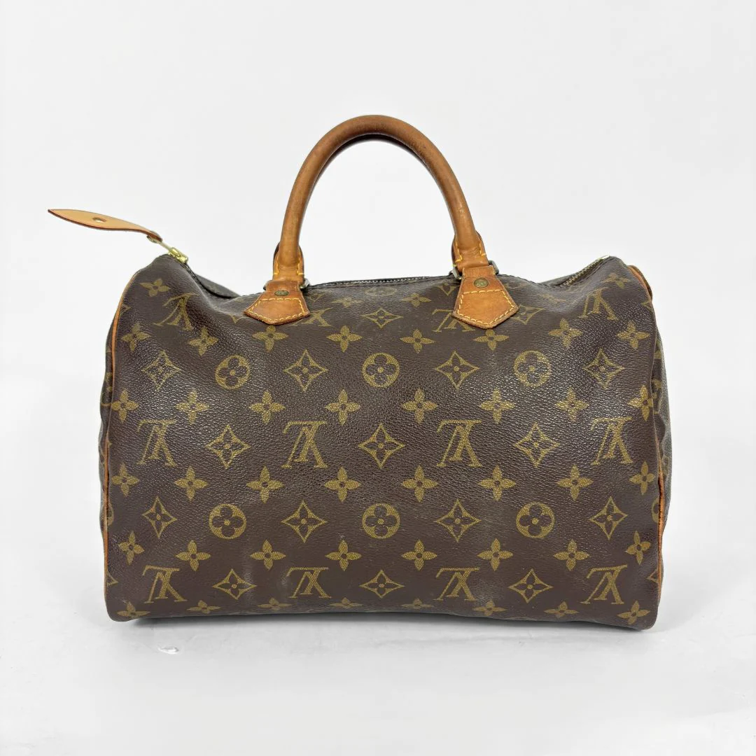 Brown handbag with monogram pattern on a white background
