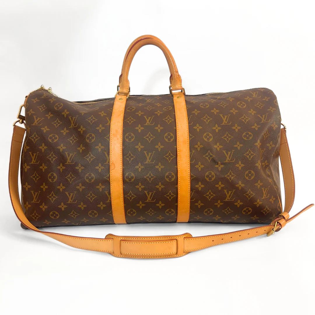 Louis Vuitton monogram duffel bag with tan leather straps on a white background