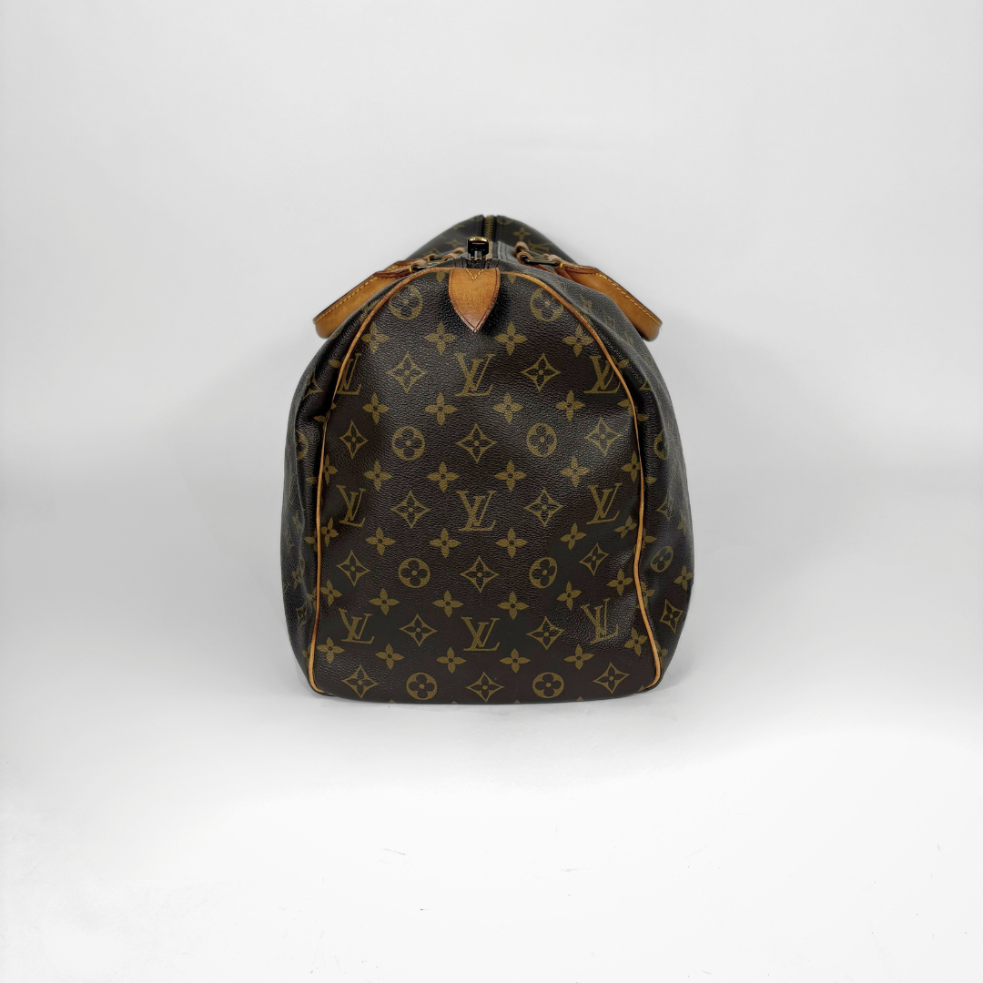 Louis Vuitton monogram travel bag with brown leather straps on a white background