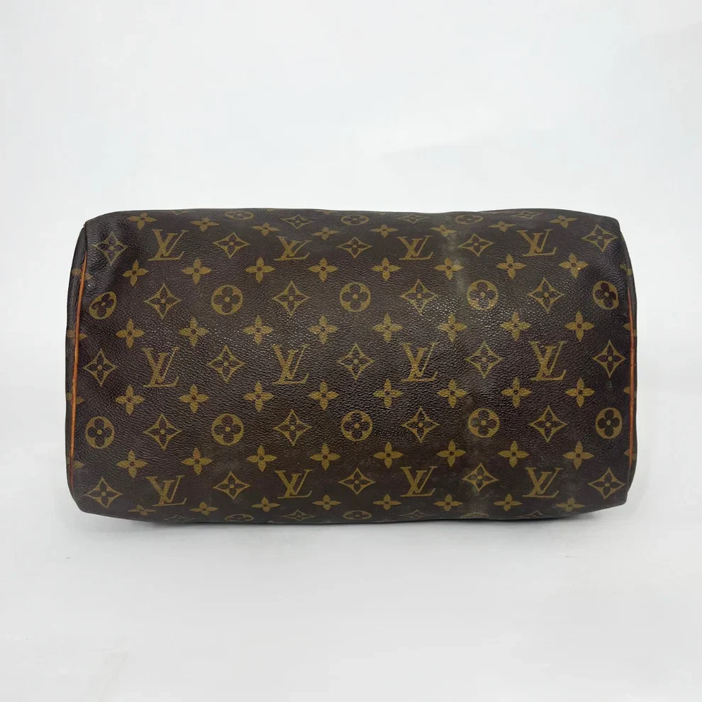 Brown leather bag with monogram pattern on a white background