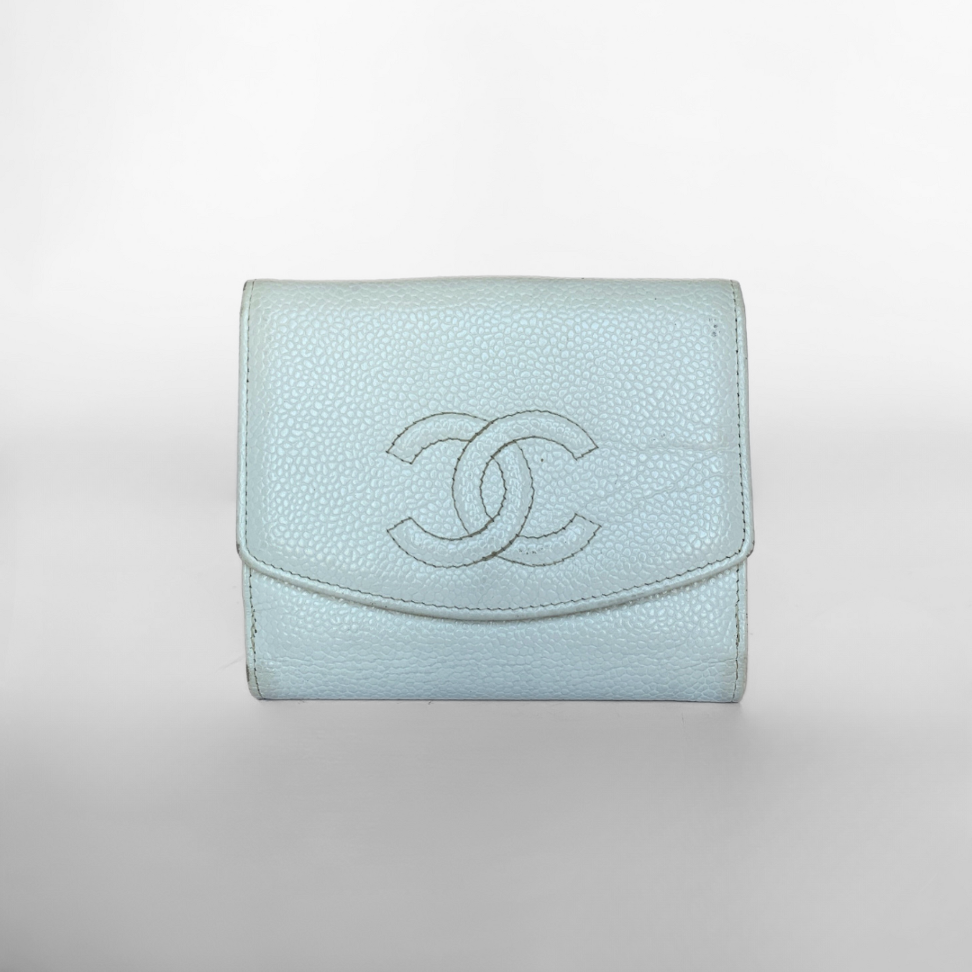 A small baby blue Chanel wallet made of caviar leather, featuring the brand's logo embossed on the front.