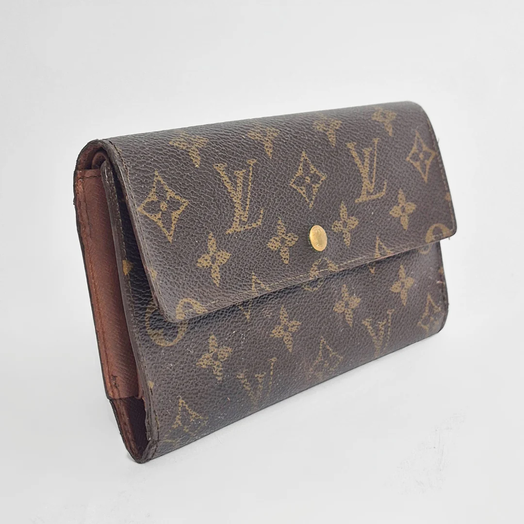 Louis Vuitton wallet with monogram pattern on a white background