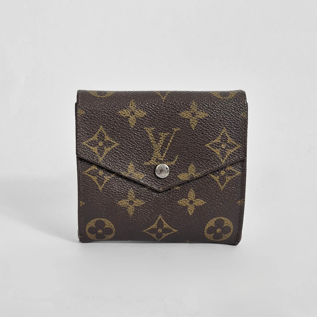 Brown wallet with gold monogram pattern on a white background