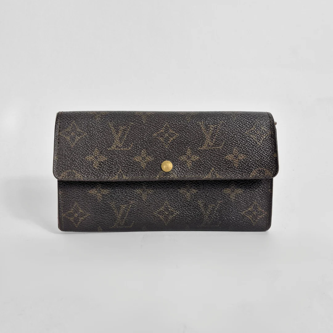 Designer wallet with monogram pattern on a light gray background