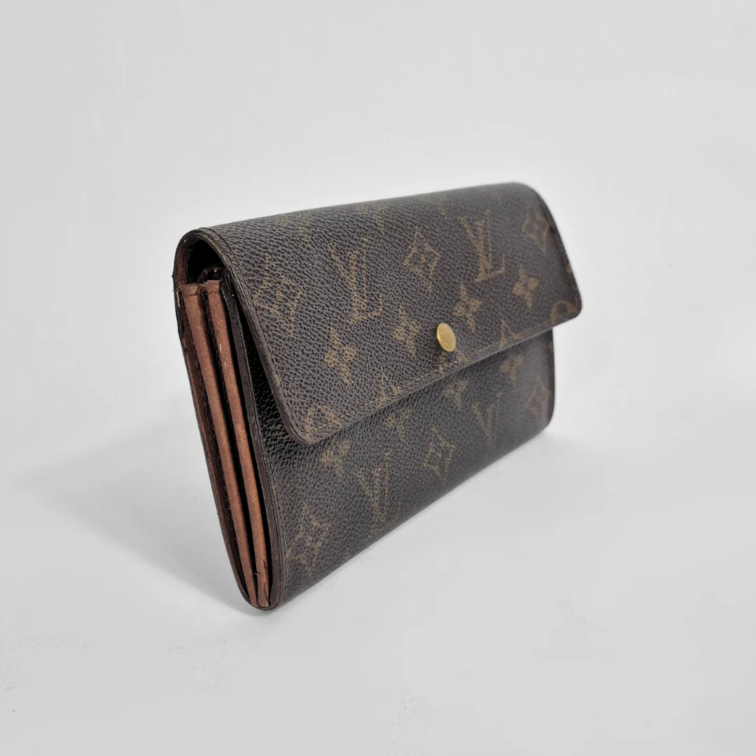 Designer wallet with monogram pattern on a light gray background