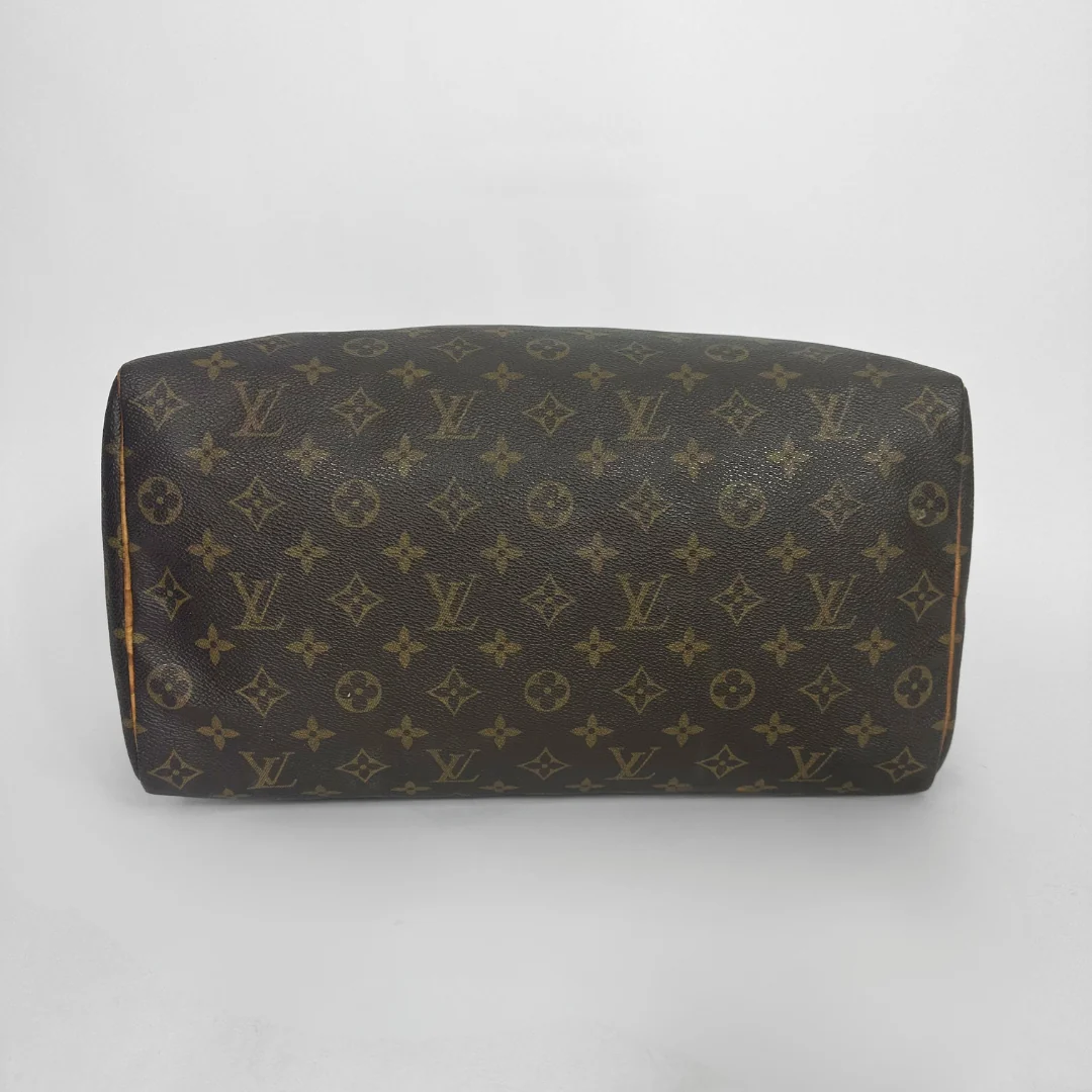 Brown handbag with a monogram pattern on a white background