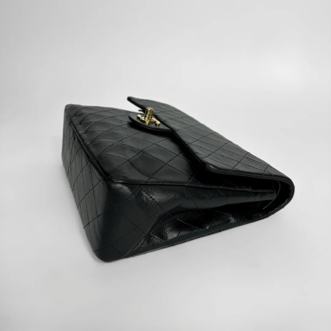 Black quilted handbag on a light gray background
