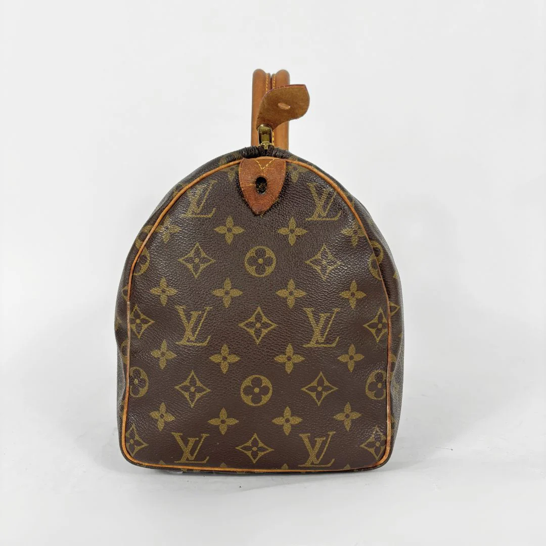 Brown handbag with monogram pattern on a white background