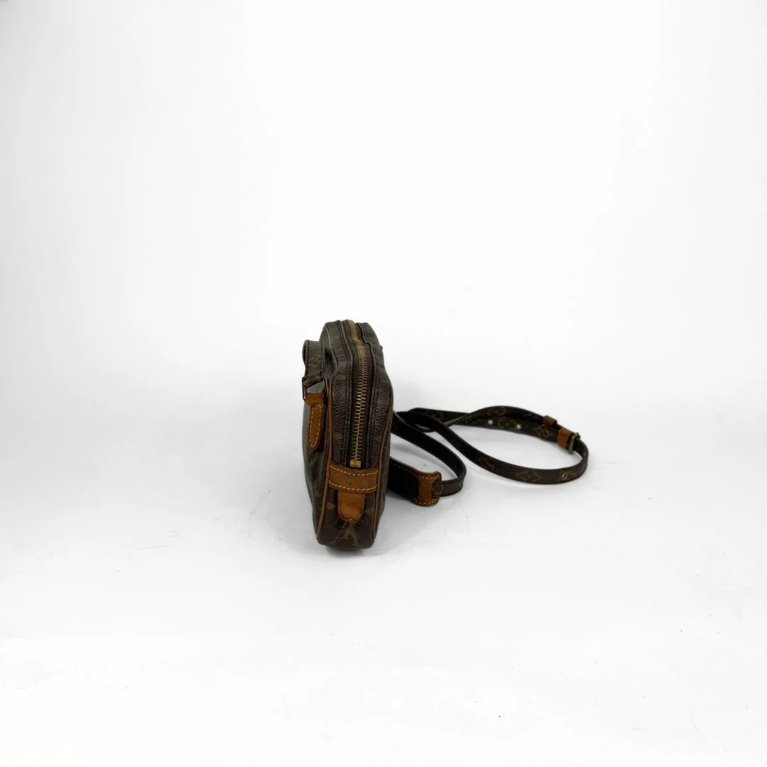 Brown leather bag with a strap on a white background