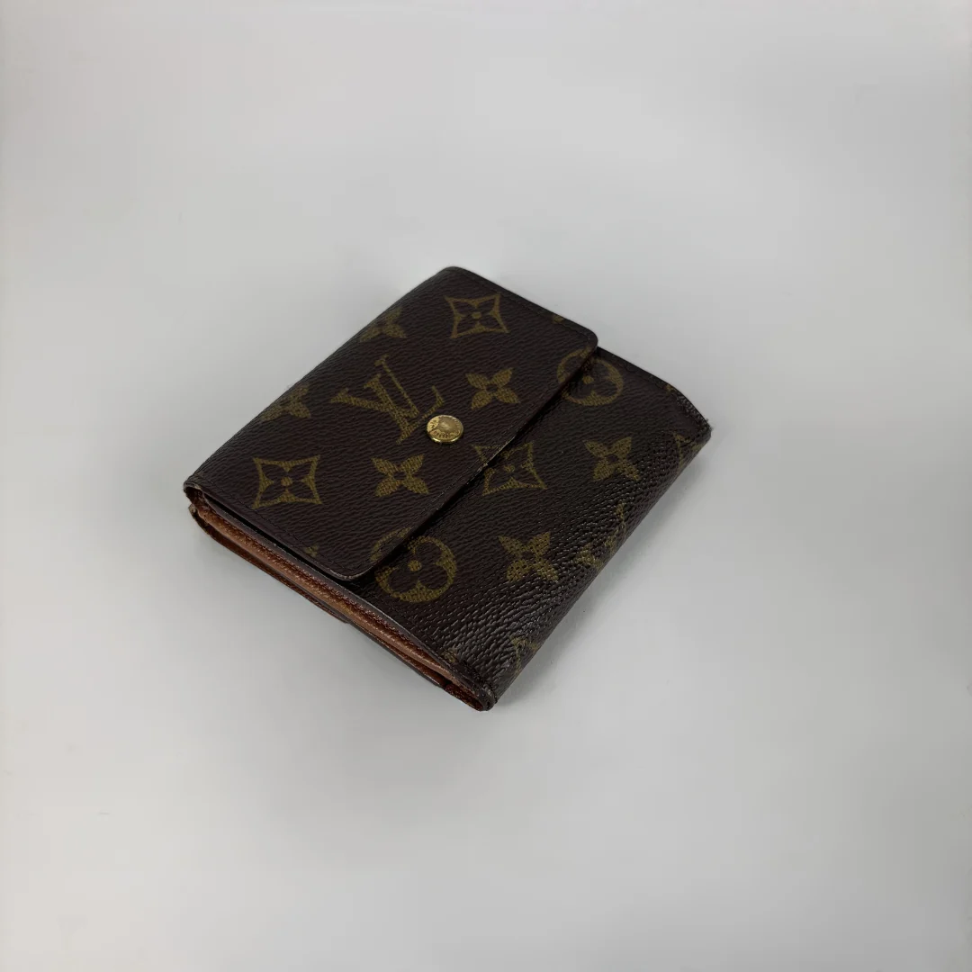 A brown monogram wallet with a gold snap button closure, photographed on a light gray background.