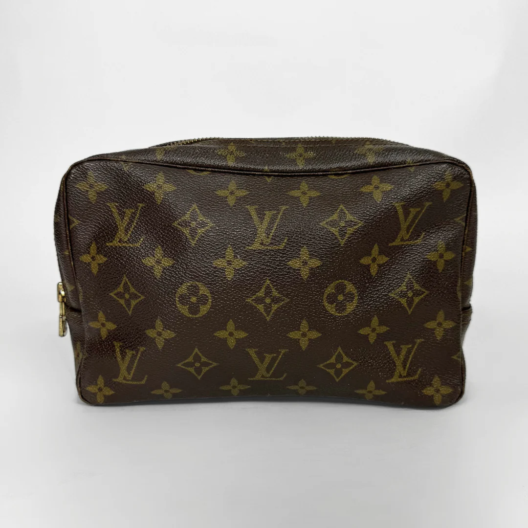 Brown leather bag with gold monogram pattern on a white background