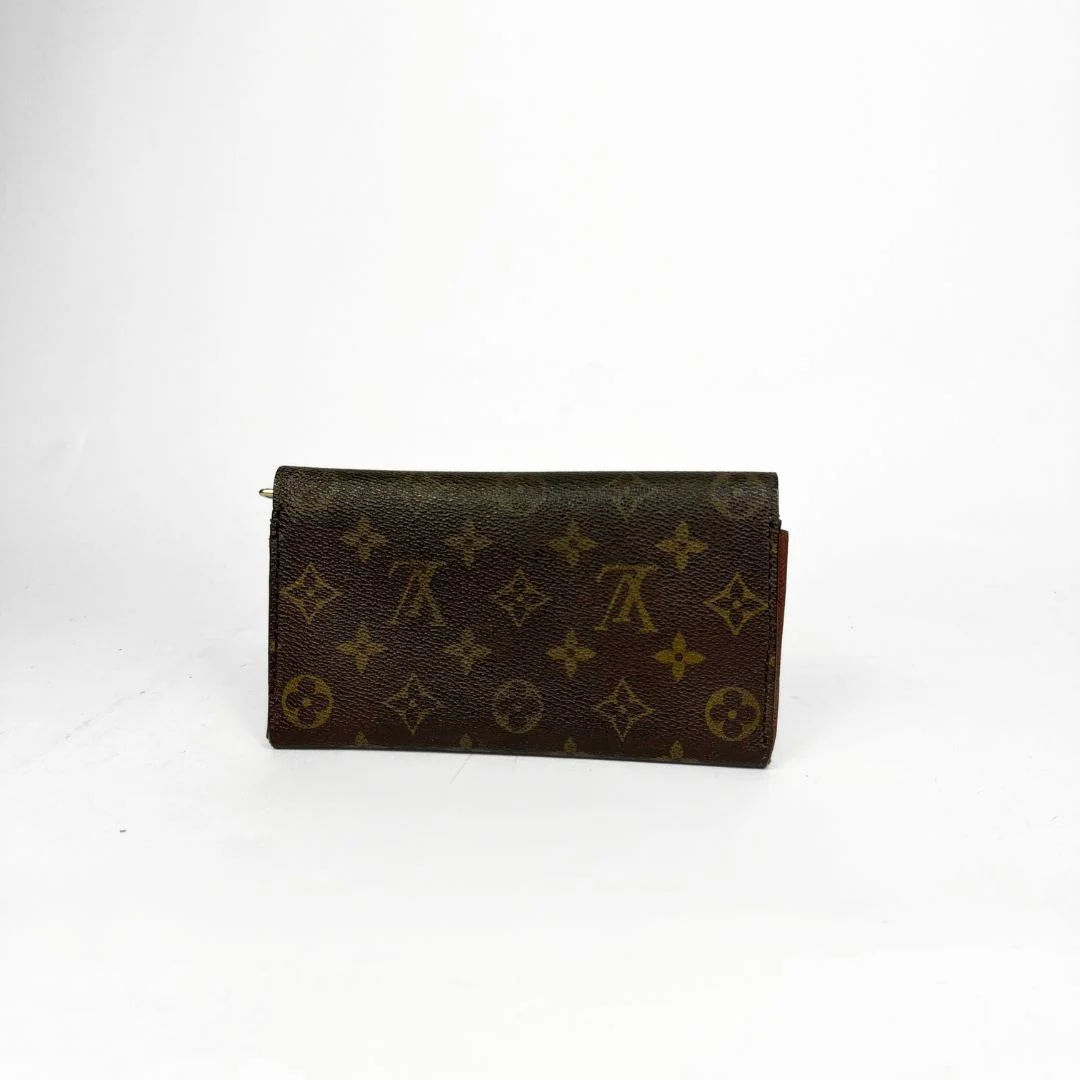 Louis Vuitton wallet with monogram pattern on a white background