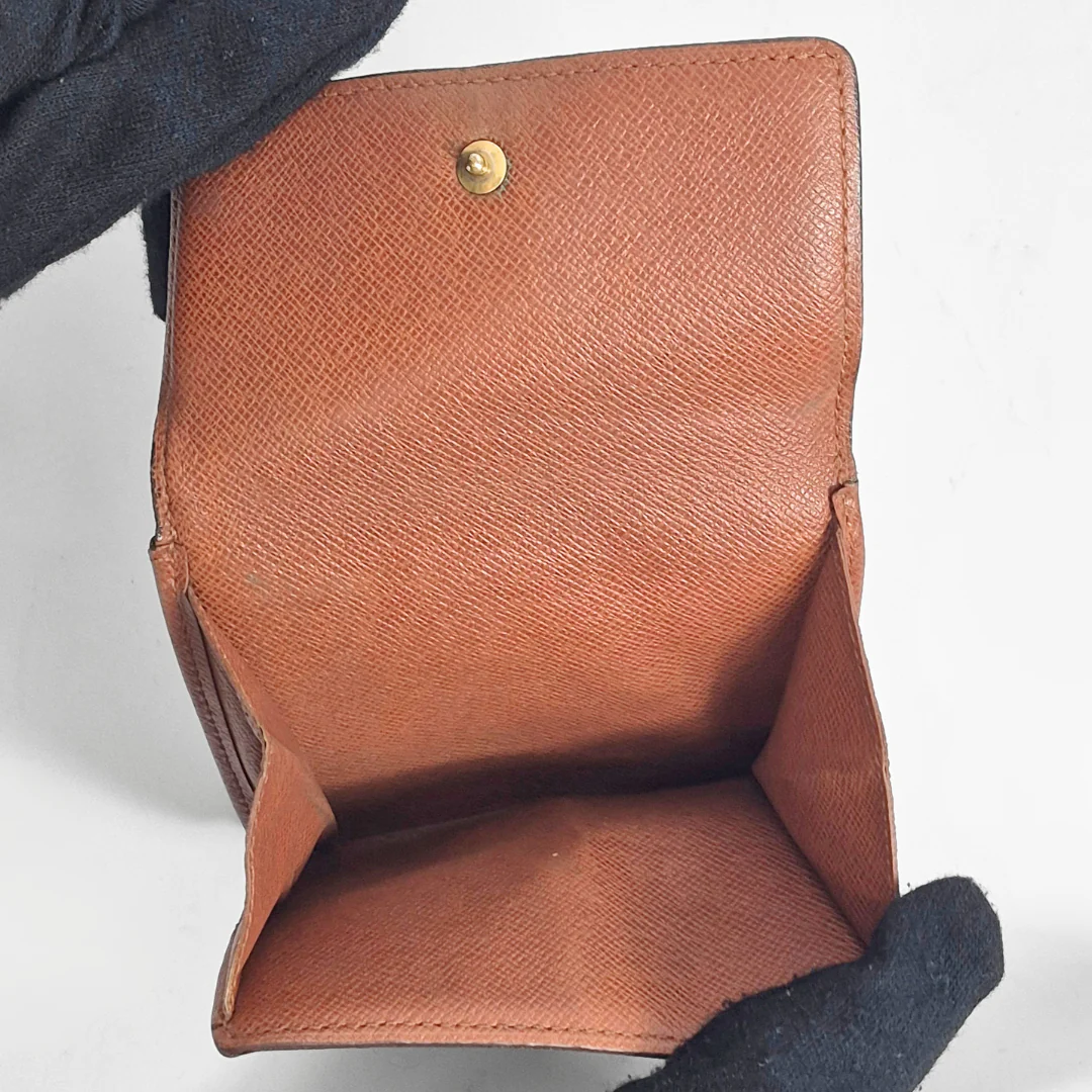 Brown leather wallet with gold button on a white background