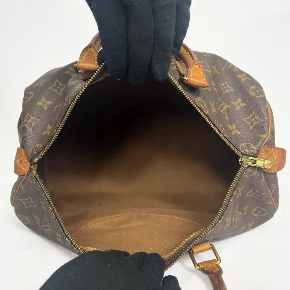 Brown Louis Vuitton handbag with monogram pattern on a white background