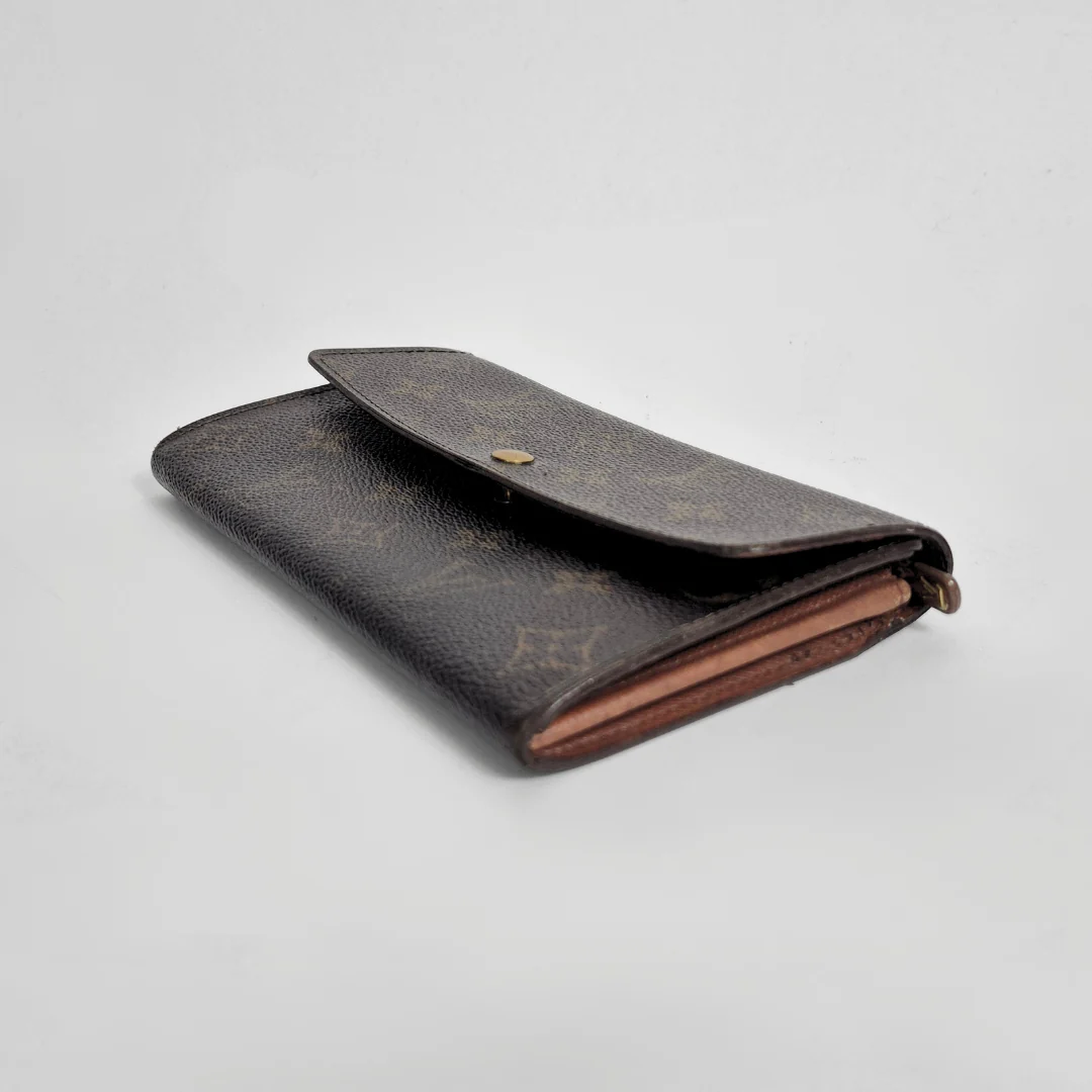 Brown leather wallet with gold accents on a light gray background