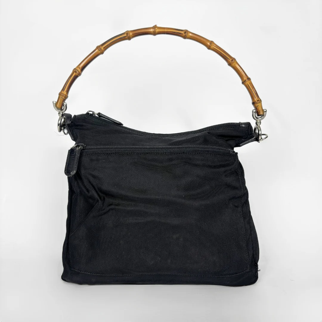 Black handbag with a bamboo handle on a white background