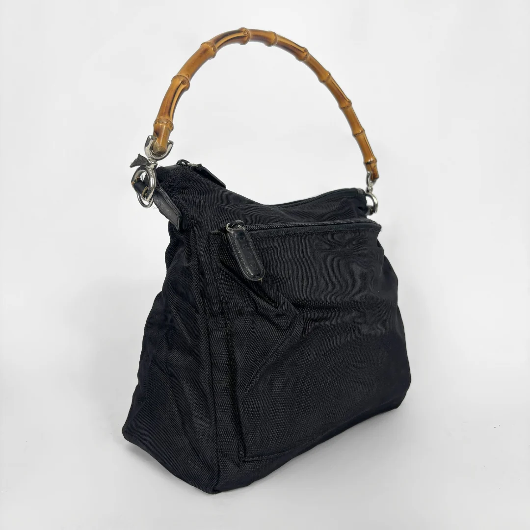 Black handbag with a bamboo handle on a white background