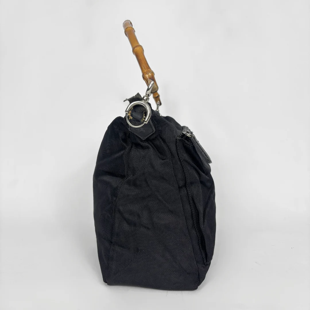 Black handbag with a bamboo handle on a white background