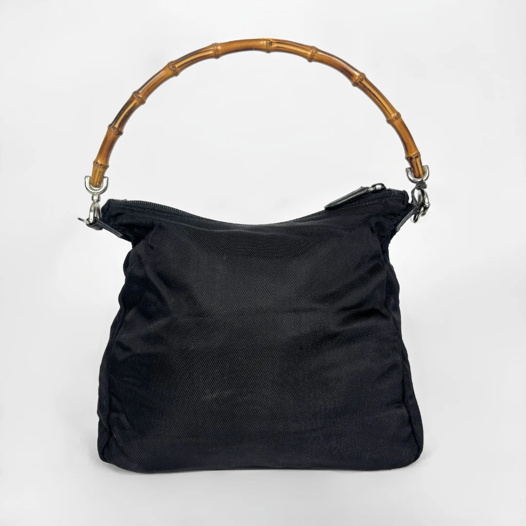 Black handbag with a bamboo handle on a white background