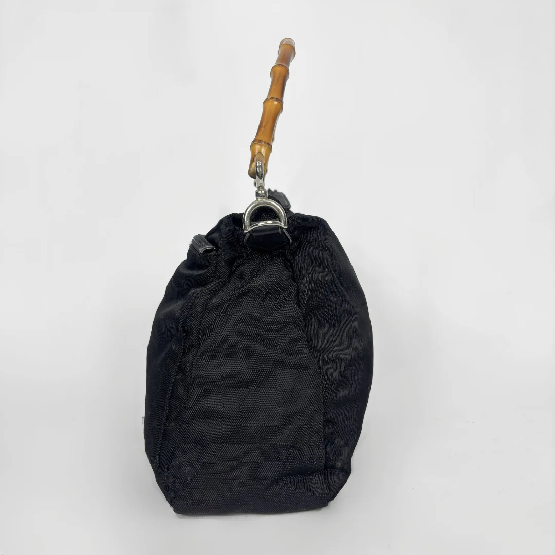 Black handbag with a bamboo handle on a white background