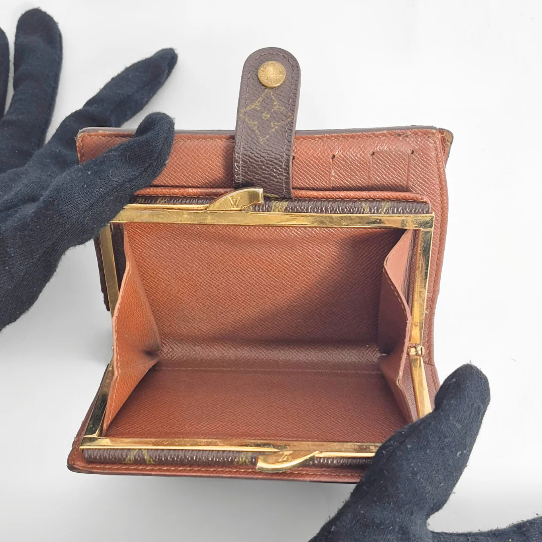 Brown leather wallet with gold accents held open 