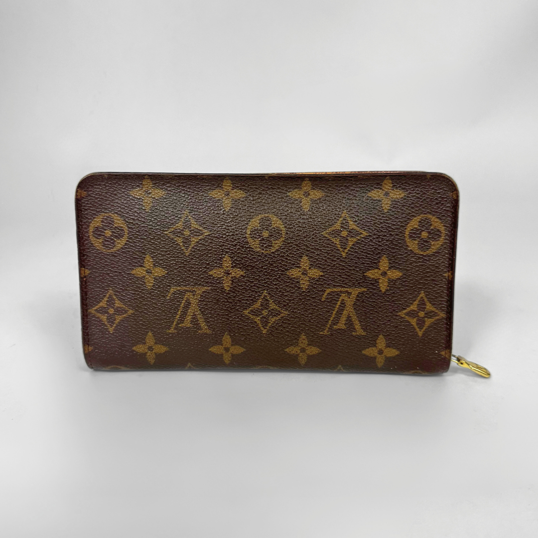 Brown wallet with gold monogram pattern on a white background