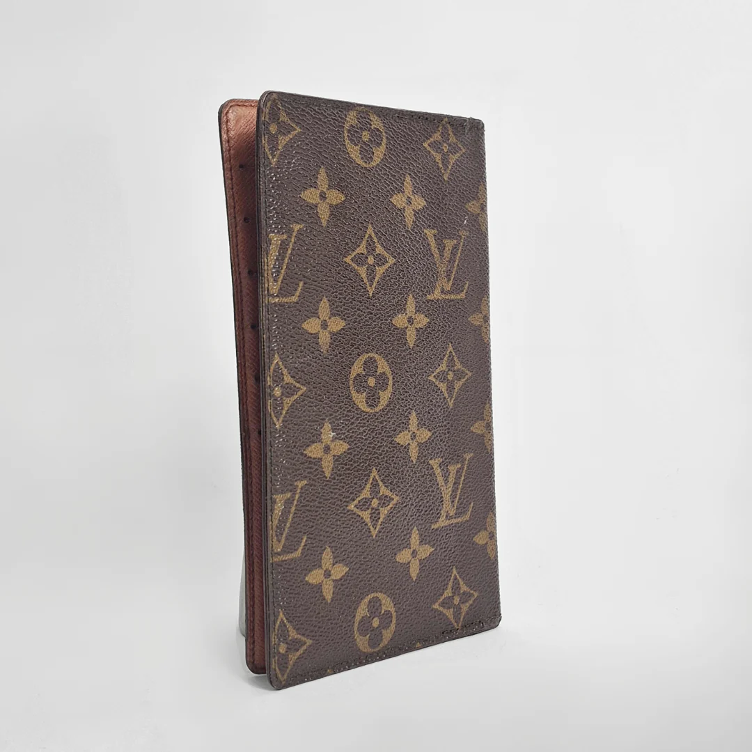 Louis Vuitton wallet with monogram pattern on a light gray background