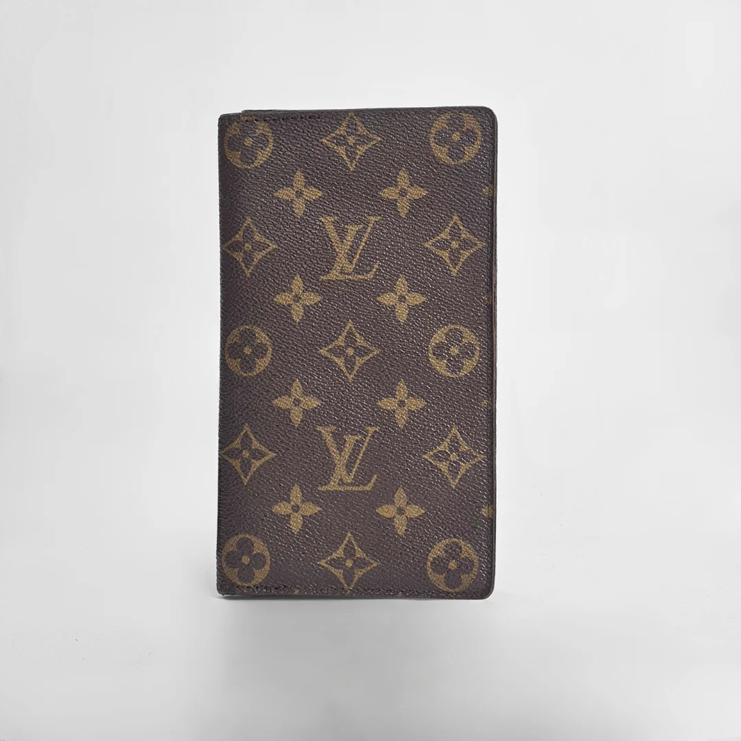 Louis Vuitton wallet with monogram pattern on a light gray background