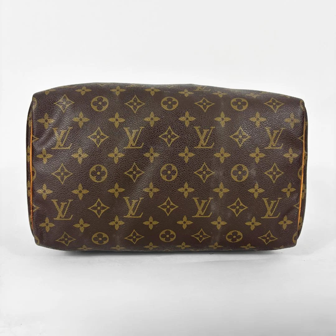 Brown handbag with monogram pattern on a white background