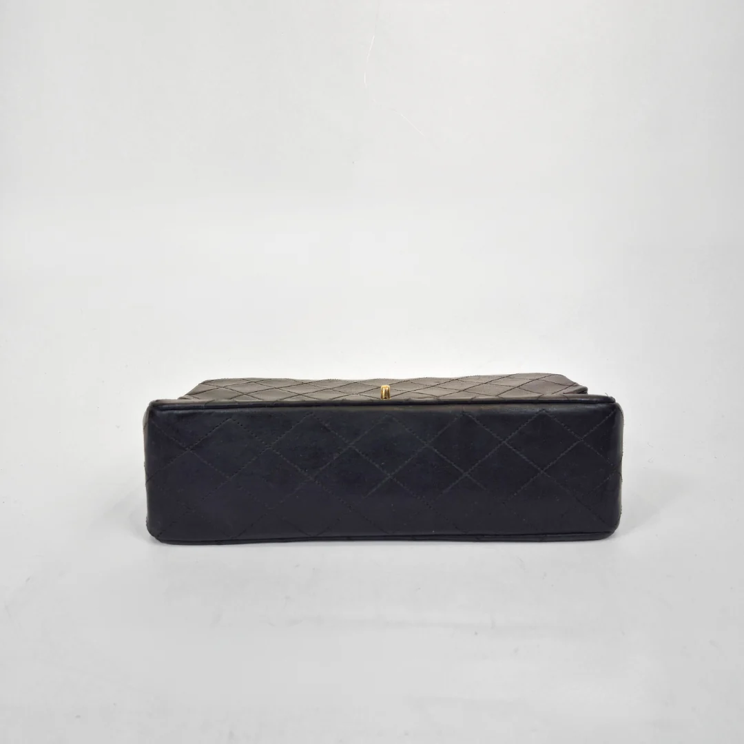 Black quilted handbag on a light gray background
