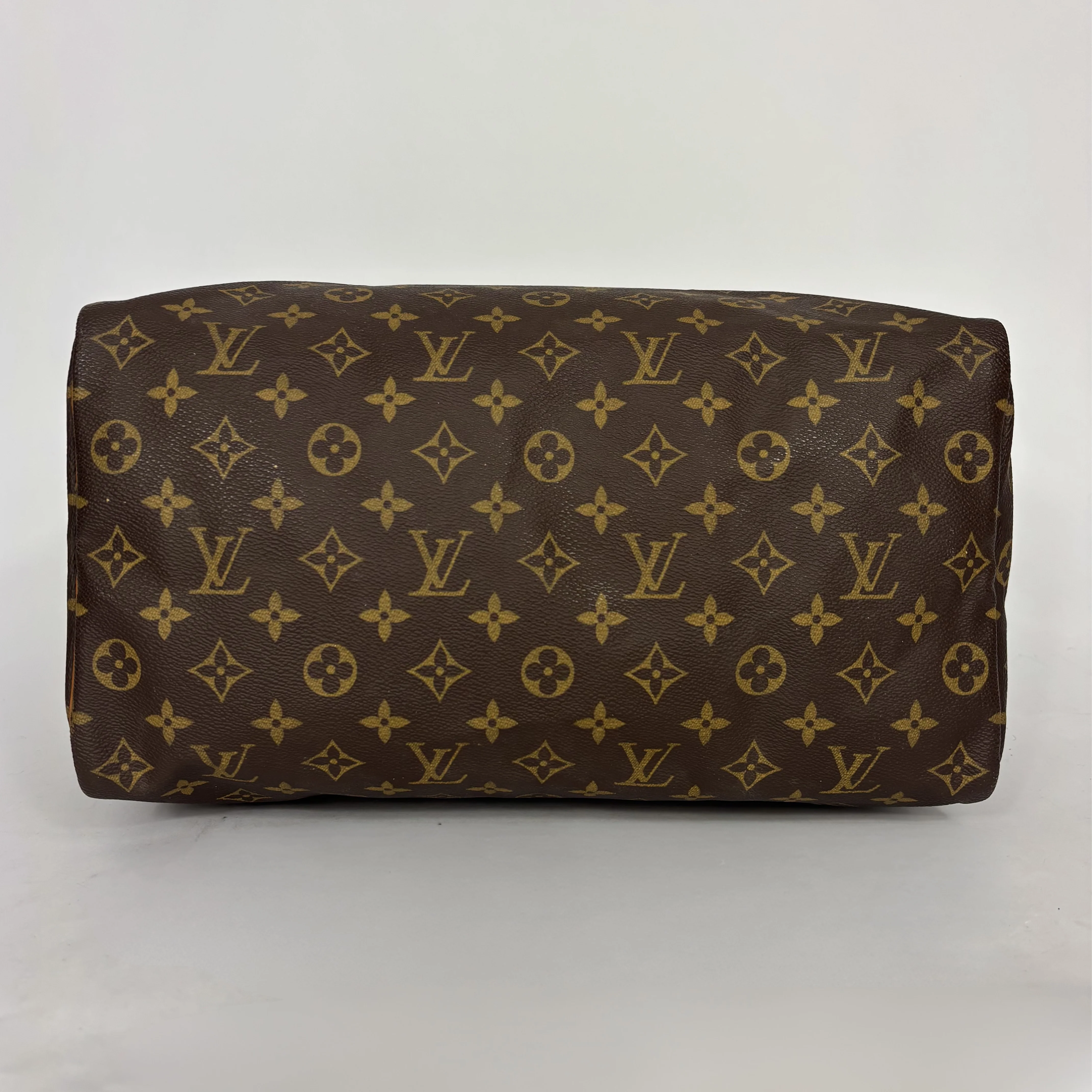 Brown leather bag with gold monogram pattern on a white background