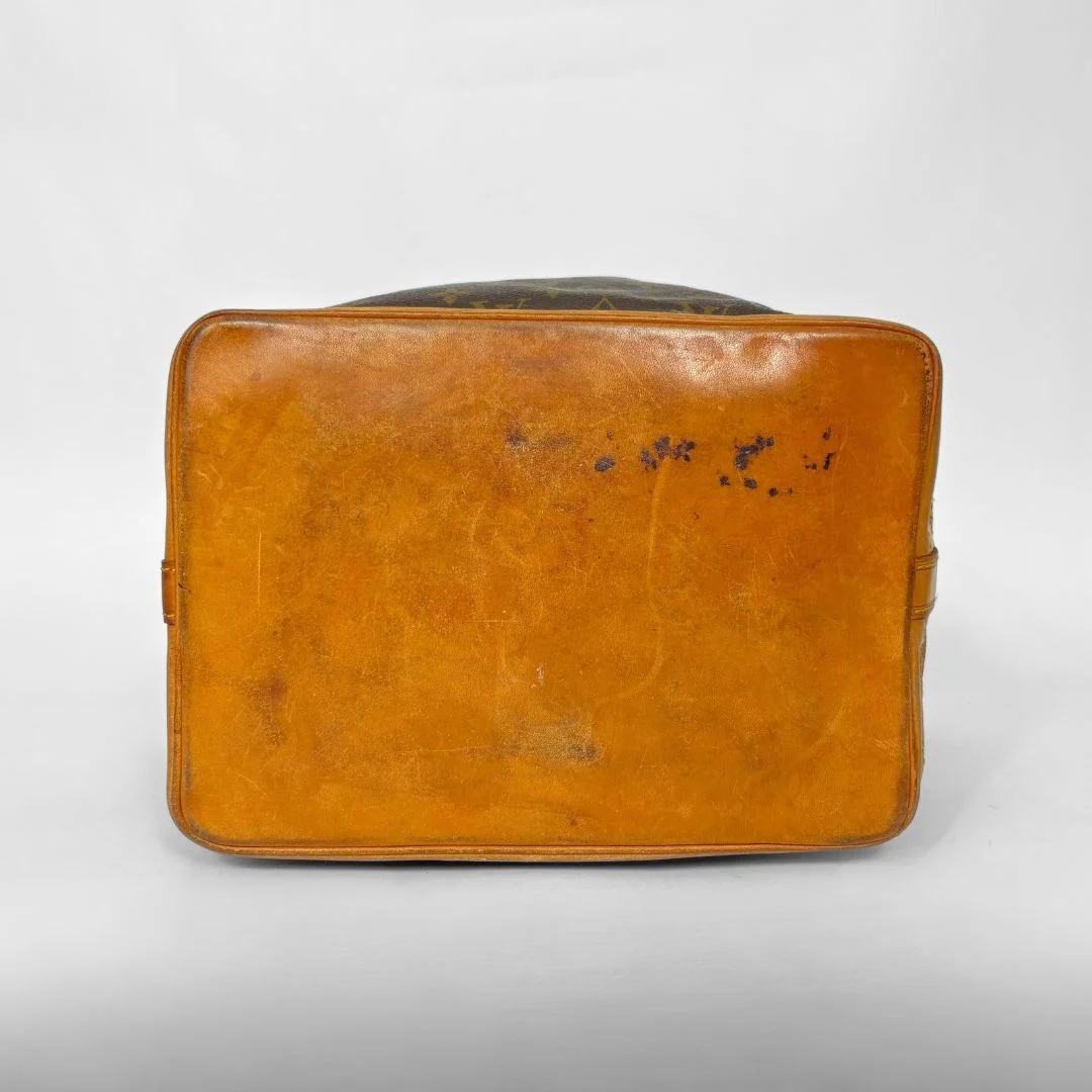Brown leather suitcase with visible wear on a white background